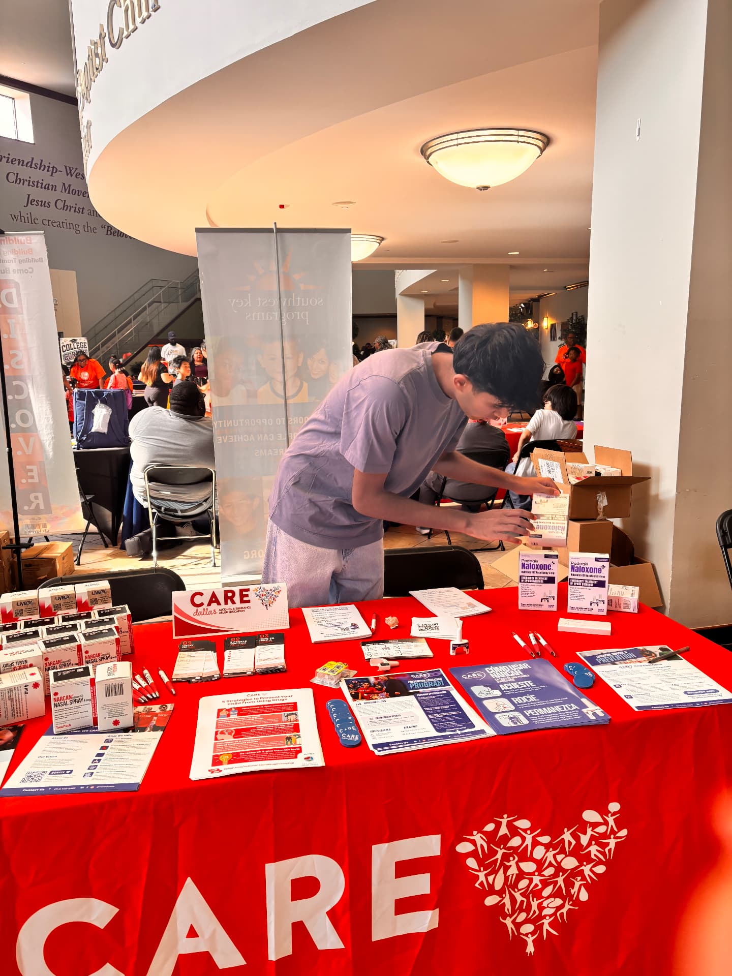 Preparing naloxone and educational materials at a CARE Dallas community event